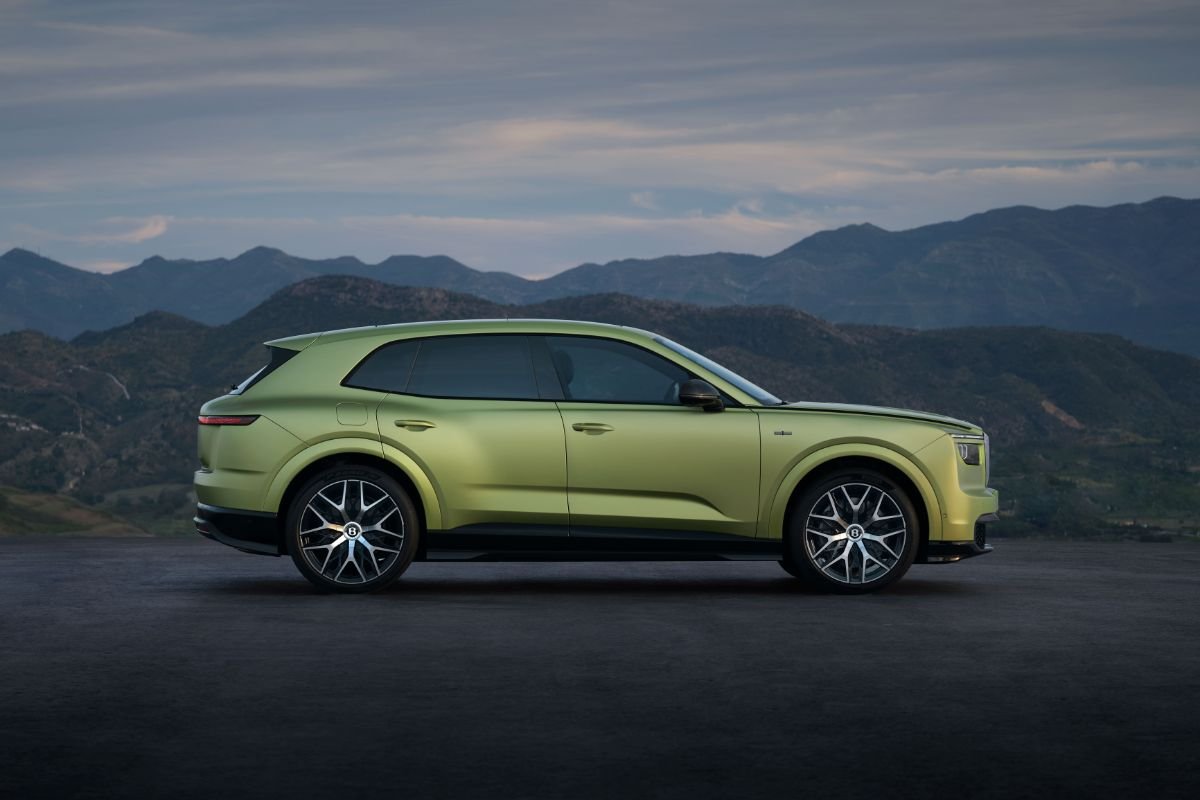 Side profile of the Bentley Torcal electric SUV in green, showcasing its sculpted bodywork, black roof and alloy wheels.
