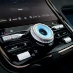 Close-up of the Bentley Torcal's illuminated blue start-stop button, surrounded by knurled metal controls on the centre console.