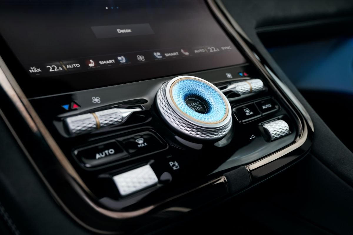 Close-up of the Bentley Torcal's illuminated blue start-stop button, surrounded by knurled metal controls on the centre console.