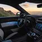 Interior of the Bentley Torcal electric SUV featuring a digital dashboard, touchscreen display, leather upholstery and illuminated door panels.
