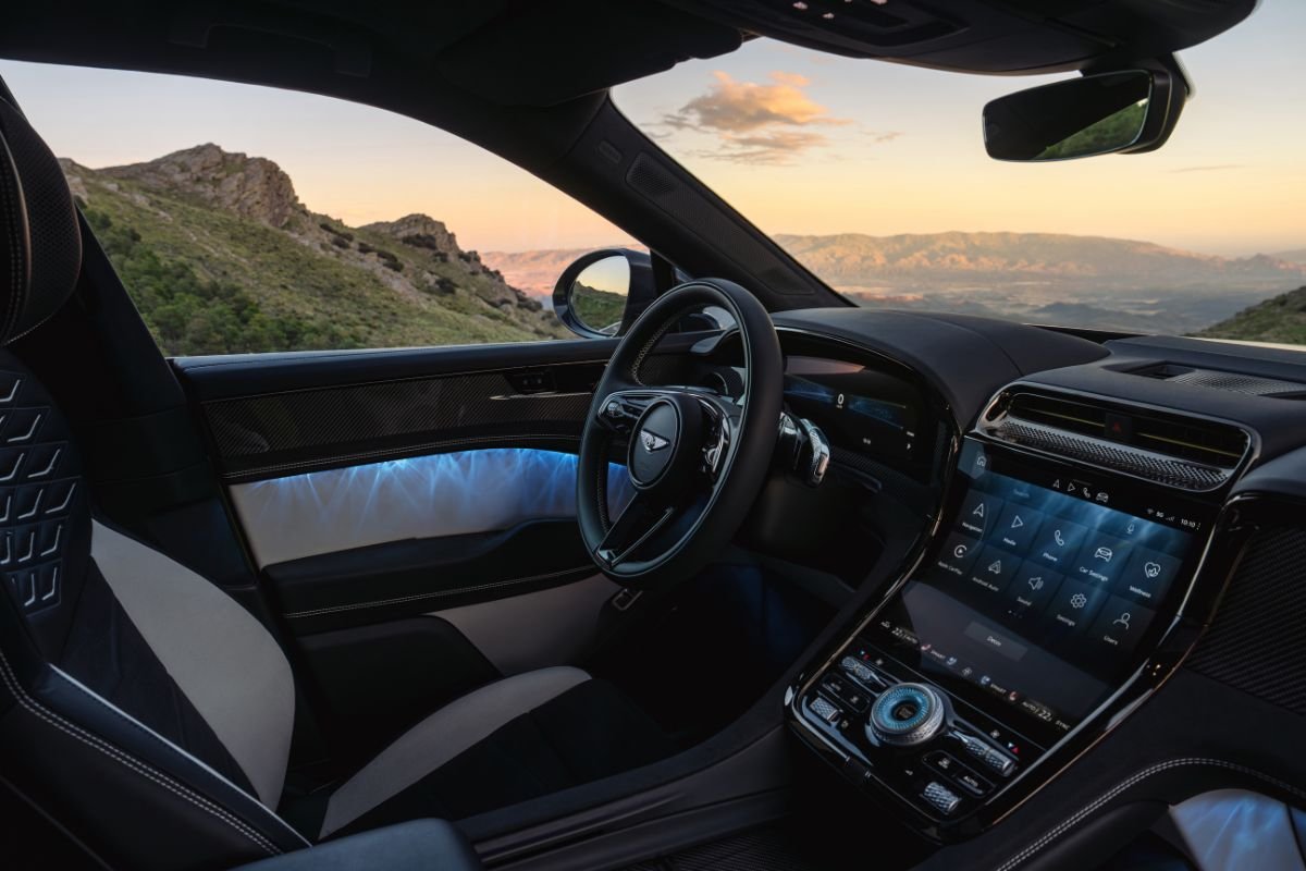 Interior of the Bentley Torcal electric SUV featuring a digital dashboard, touchscreen display, leather upholstery and illuminated door panels.