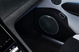 Close-up of a Naim audio speaker with an intricate circular grille inside the Bentley Torcal electric SUV.