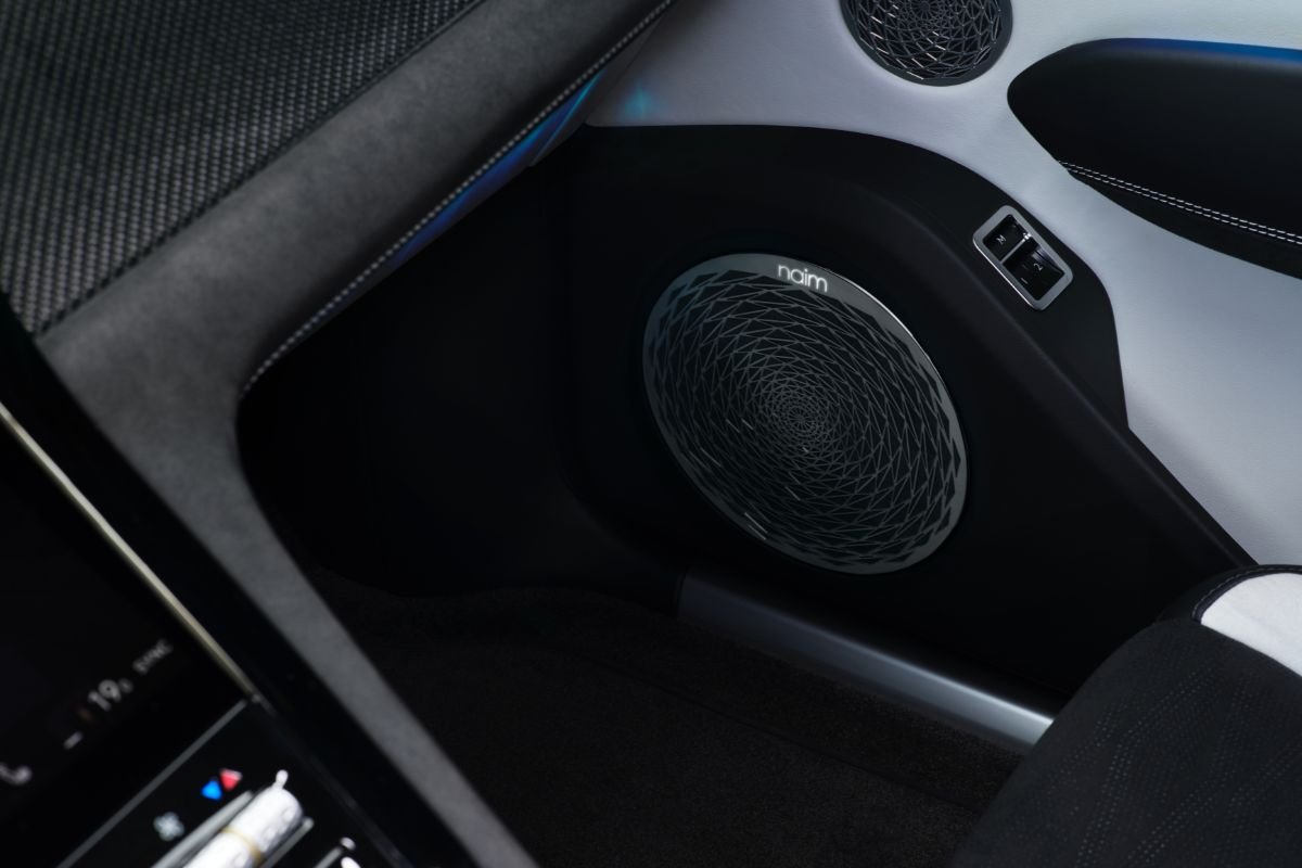 Close-up of a Naim audio speaker with an intricate circular grille inside the Bentley Torcal electric SUV.