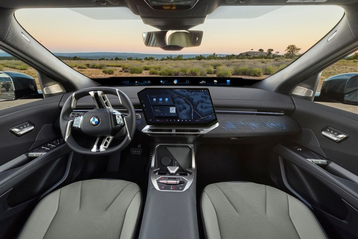 BMW iX4 interior dashboard featuring the central touchscreen and Panoramic iDrive display.