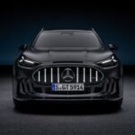 Front view of the black Mercedes-AMG GT SUV with illuminated vertical grille bars and LED headlights.