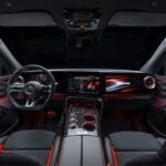 Wide view of the Mercedes-AMG GT SUV cockpit featuring digital displays, ambient red lighting and a carbon-fibre centre console.