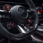 Close-up of the Mercedes-AMG GT SUV performance steering wheel with AMG controls, digital instrument display and carbon-fibre trim.