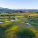 Aerial view across the championship golf course at Verdura Resort, with green fairways, bunkers and distant mountains.