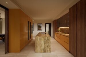 Contemporary villa kitchen with warm terracotta cabinetry, a natural stone island and dark timber finishes.