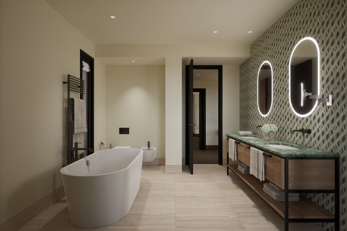 Contemporary bathroom with a freestanding bathtub, green marble double vanity and illuminated oval mirrors.