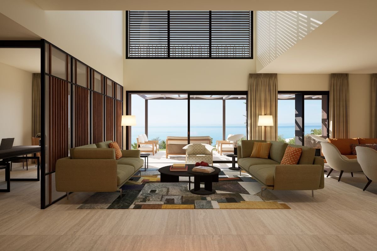 Double-height living room with contemporary seating and large sliding doors opening towards the Mediterranean Sea.