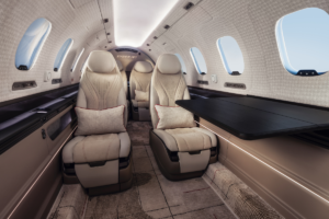 Proposed SyberJet SJ36 cabin interior featuring cream leather passenger seats and a large fold-out table.