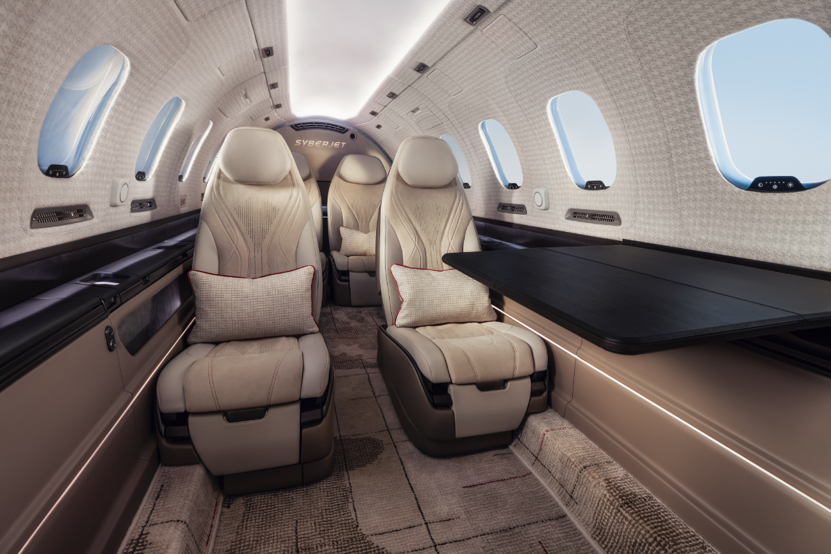 Proposed SyberJet SJ36 cabin interior featuring cream leather passenger seats and a large fold-out table.