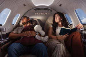 Family travelling in a SyberJet private jet cabin, with one passenger reading beside reclining seats.