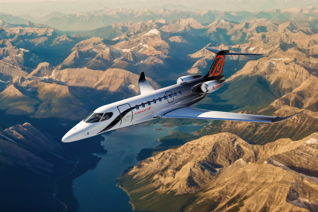 Rendering of the SyberJet SJ36 private jet flying above a mountainous landscape and lake.