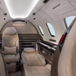 Rear seating area of the proposed SyberJet SJ36 interior with reclining cream leather seats and overhead lighting.