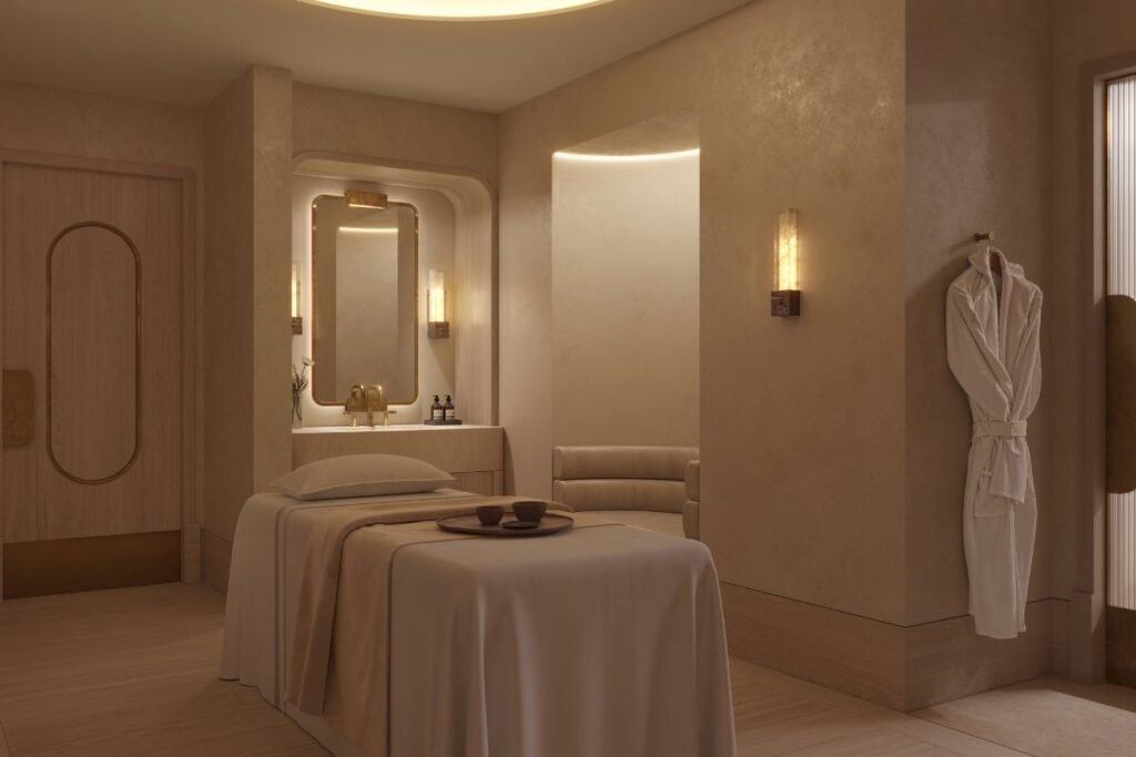 A luxury spa treatment room at Waldorf Astoria London – Admiralty Arch, featuring a massage bed, warm neutral interiors and soft lighting.