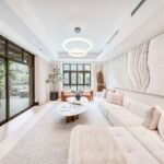 Contemporary living room with cream sofas, large abstract artwork and sliding glass doors opening onto the terrace.