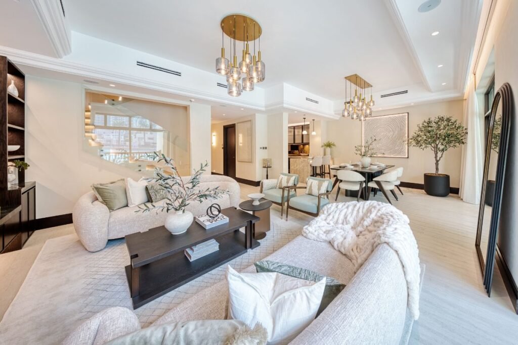 Spacious open-plan living and dining room with sculptural chandeliers, neutral furniture and contemporary artwork.